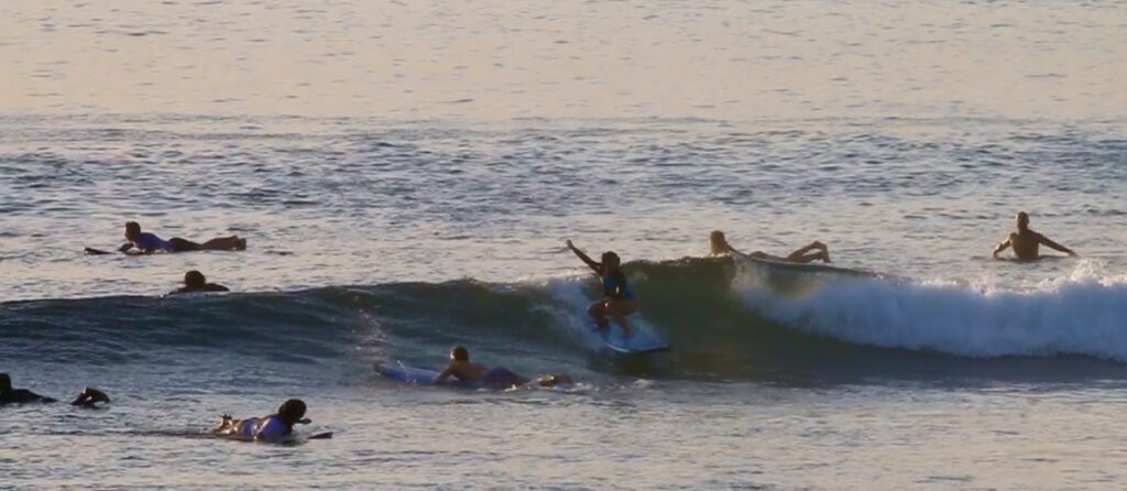 Beginner student doing sunset surf at Padang-Padang beach